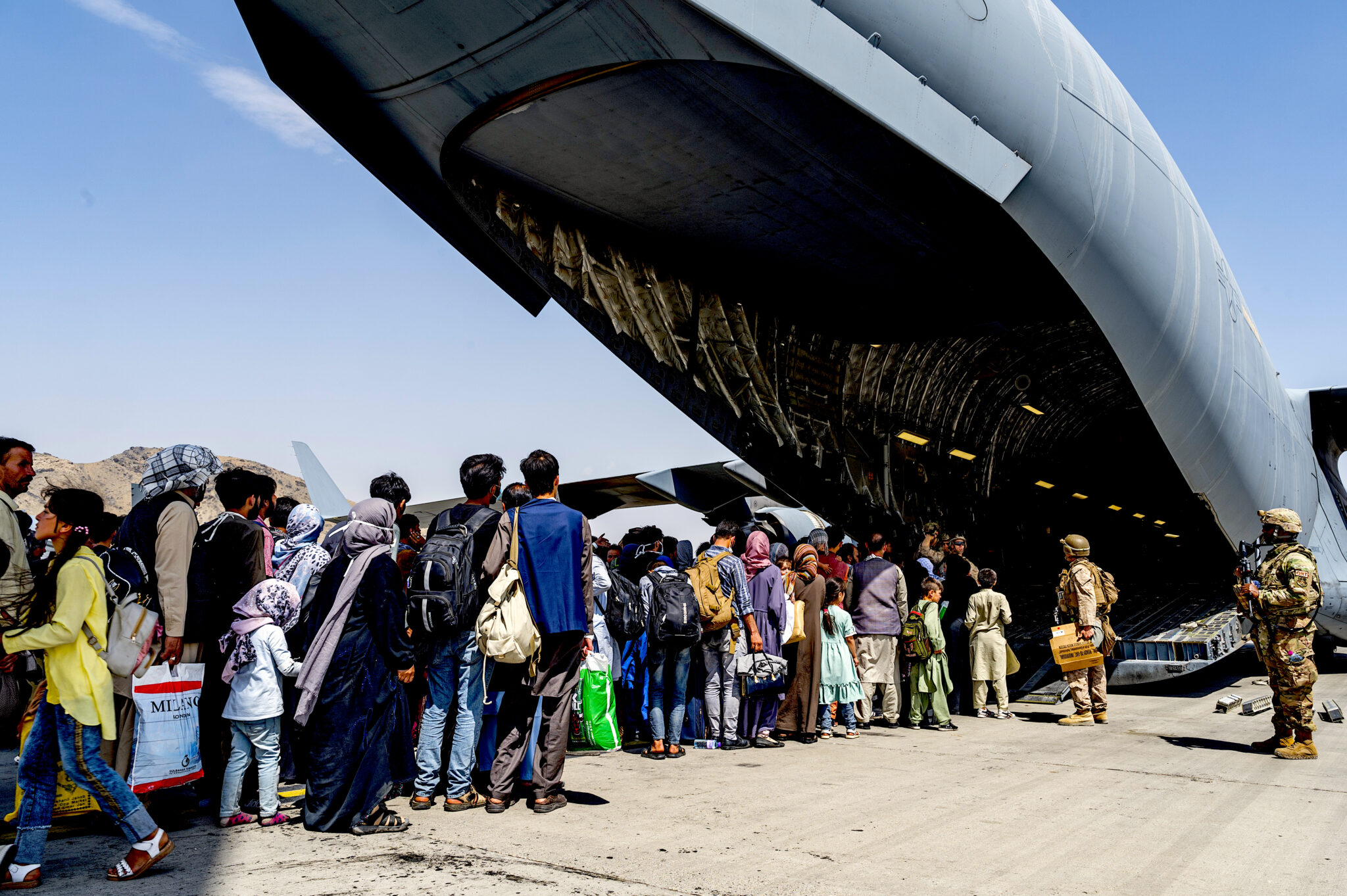 U.S. soldiers with Afghans boarding a C-17 Globemaster III at Hamid Karzai International Airport on Aug. 21 after the Taliban captured Kabul. (U.S. Air Force, Brennen Lege)